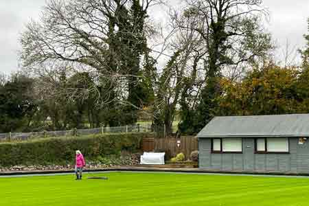 lady sweeping bowls green