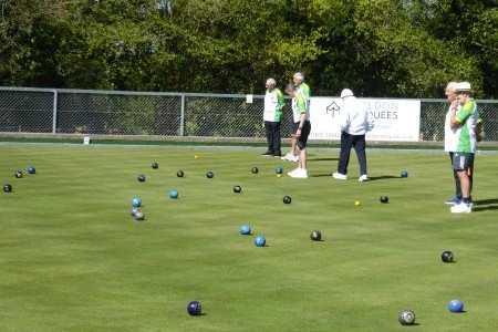 bowlers on the green with bowls and jacks visible