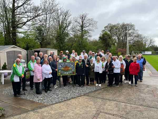 Picture of members gathered round Mosaic sign.